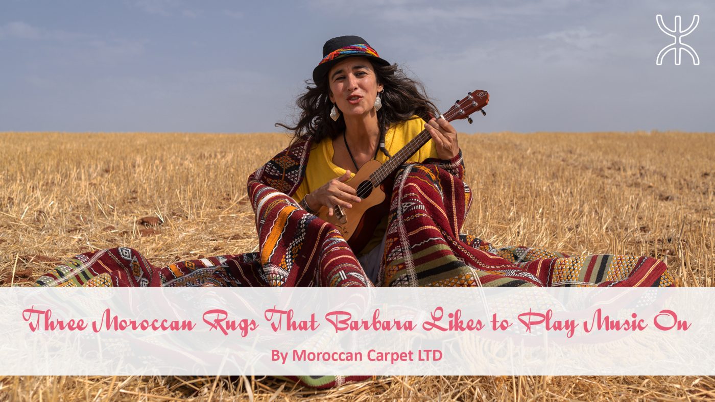 a woman sitting in a field with a guitar. 06 – Three Moroccan Rugs That Barbara Likes to Play Music On 01