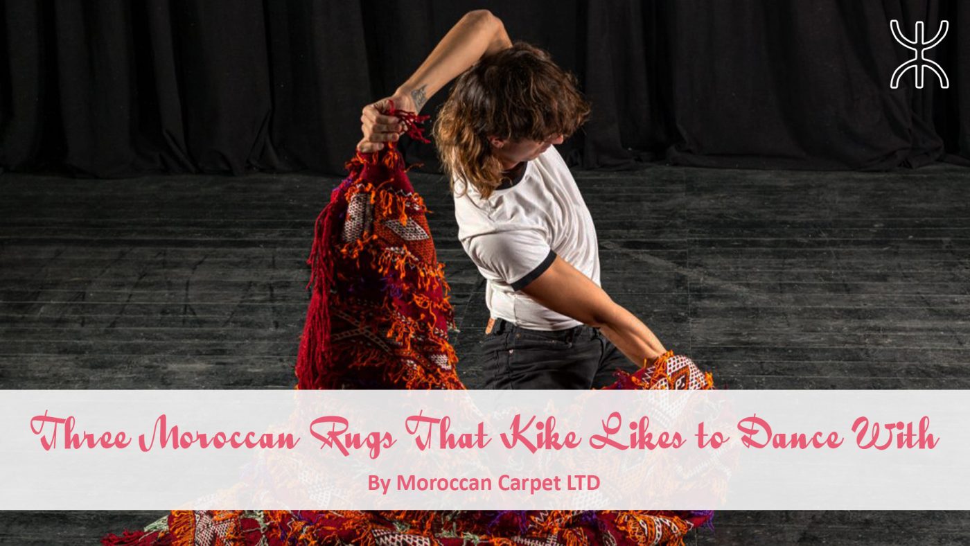 a woman in a white shirt and black pants is holding a red moroccan rug. 08 – Three Moroccan Rugs That Kike Likes to Dance With 01