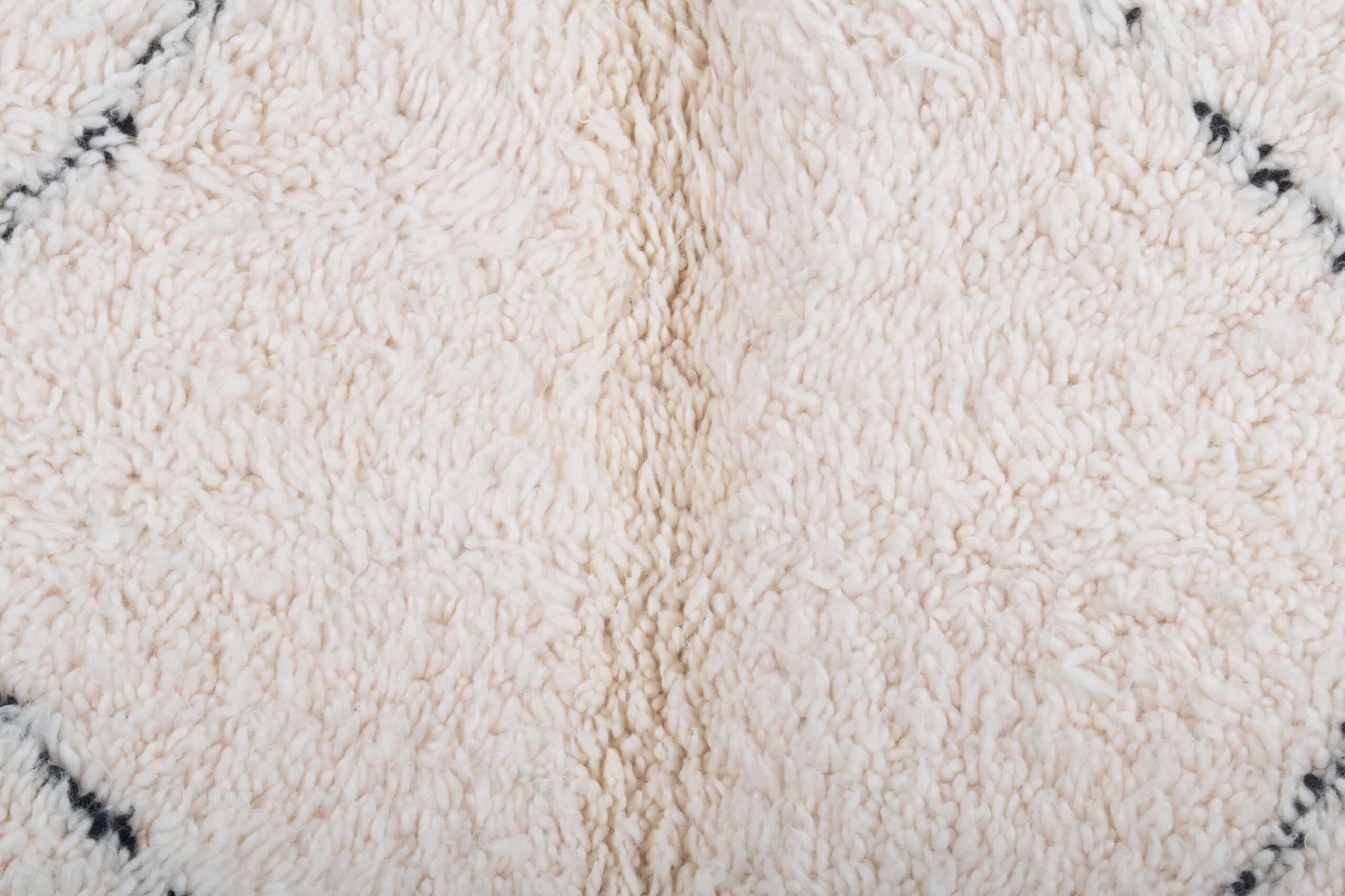 a close up of a white rug with black and white designs. BNO-065_W-40_BK_259-159 (7)