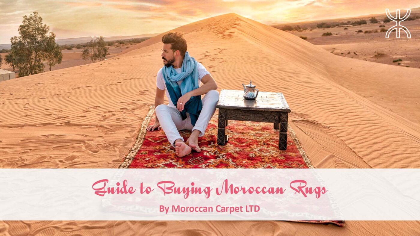 a woman sitting on a rug in the desert. Guide to Buying Moroccan Rugs 01