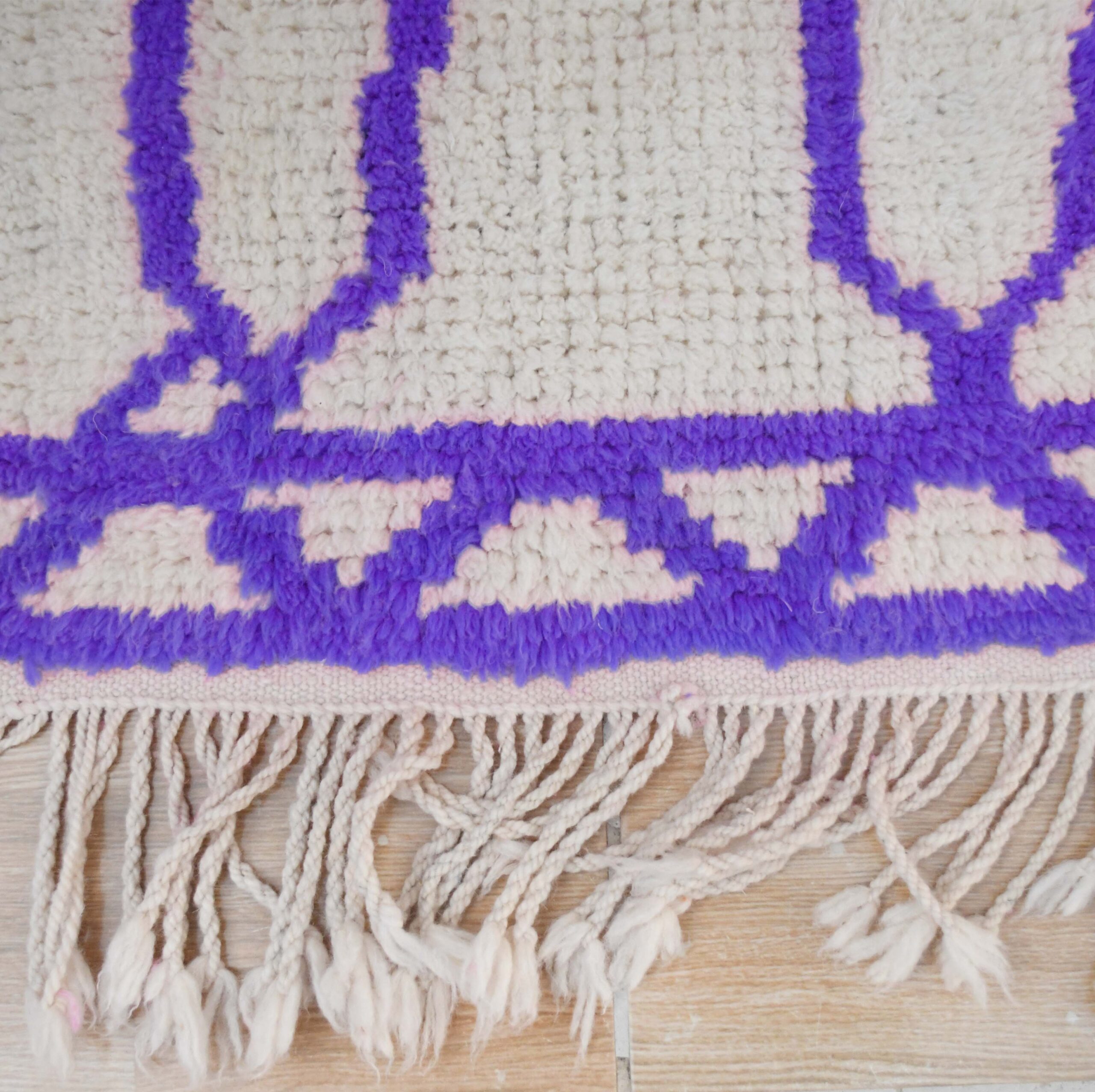 a purple and white rug with fringes on a wooden floor. VIN311_W-40_PR-19_BK-39_GR-13_02