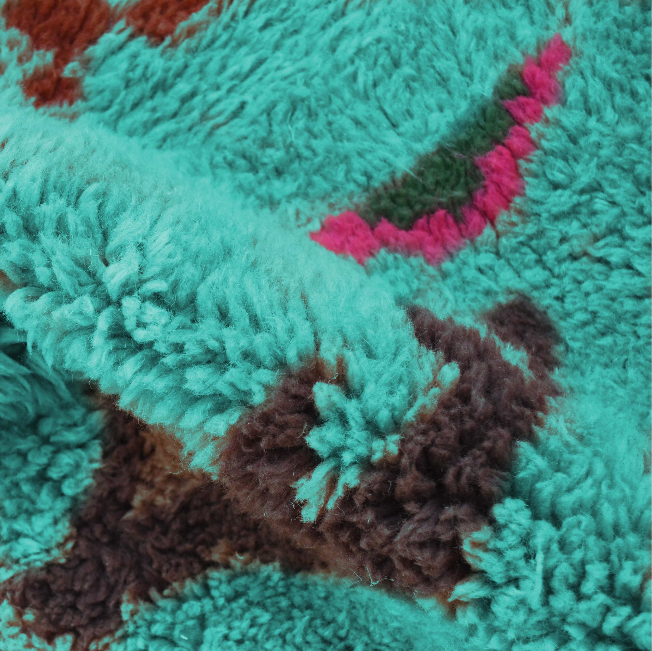 a close up of a green and brown rug. VIN312_BL-09_GR2-97_GR-11_OR-24_PN-35_PN-33_BL-09_BR-302_BR-32_BR-28_PR-19_GY_37_BK-39_07