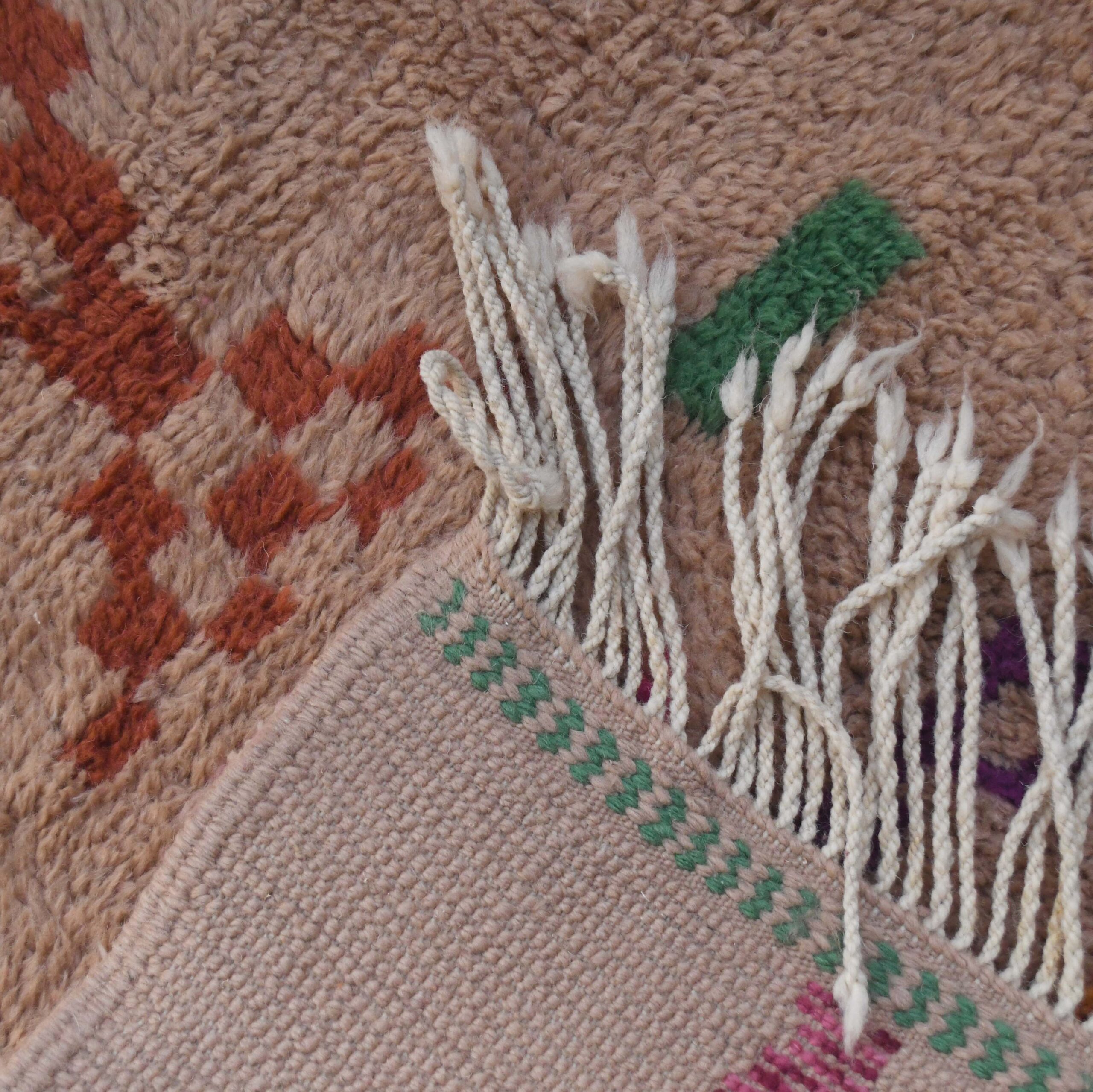 a close up of a rug with a piece of yarn. VIN312_CR-01_GR2-97_GR-11_OR-24_PN-35_PN-33_BL-09_BR-302_BR-32_BR-28_PR-19_GY_37_BK-39_06