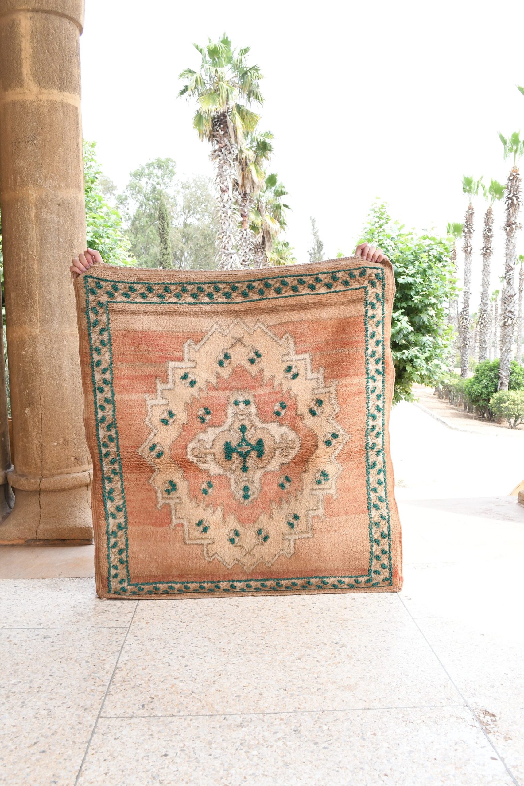 a woman holding a rug in front of a building. il_fullxfull.6021324458_jrmg.jpg