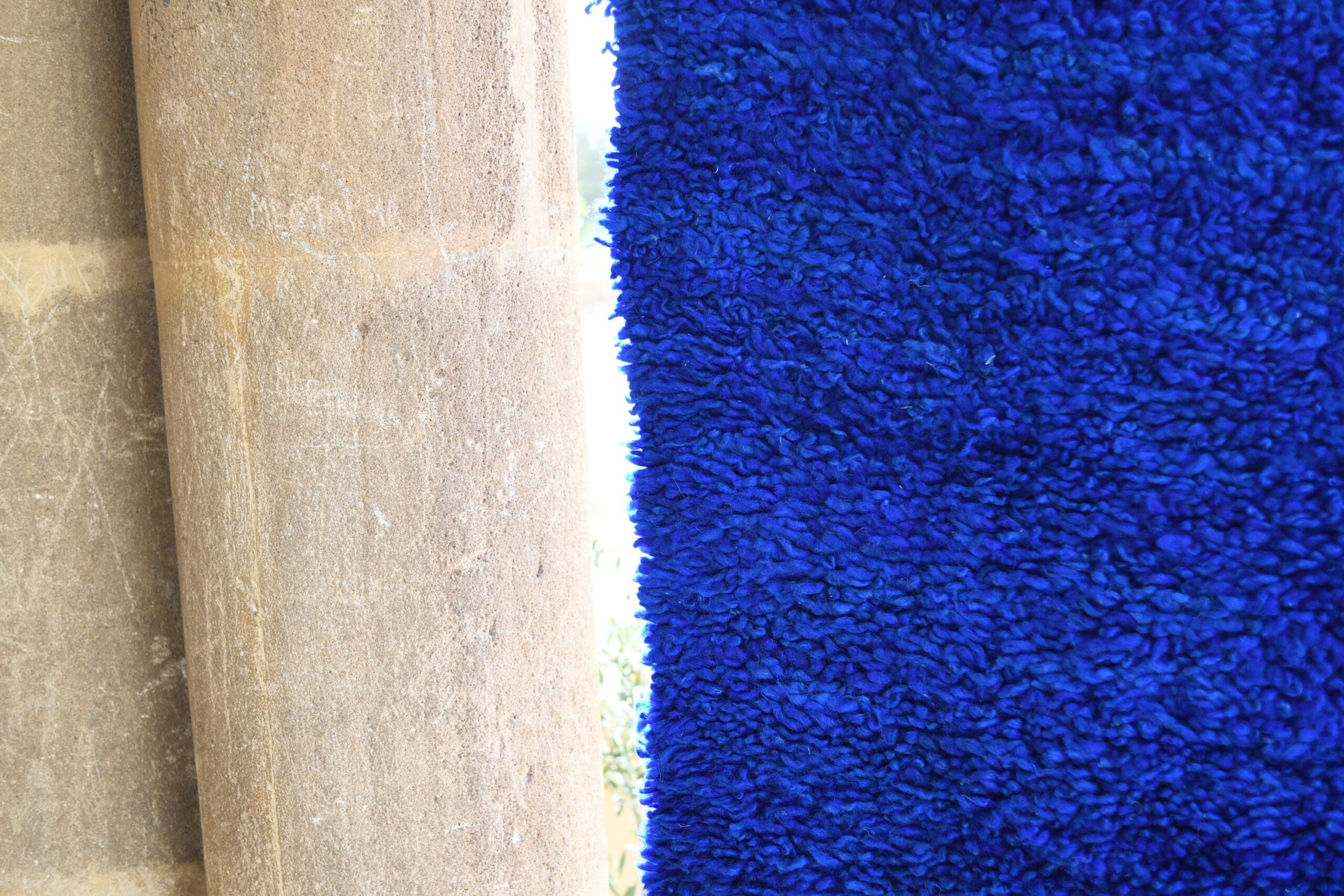 a blue rug with a wooden pole in the background. il_fullxfull.6021350446_ai53.jpg