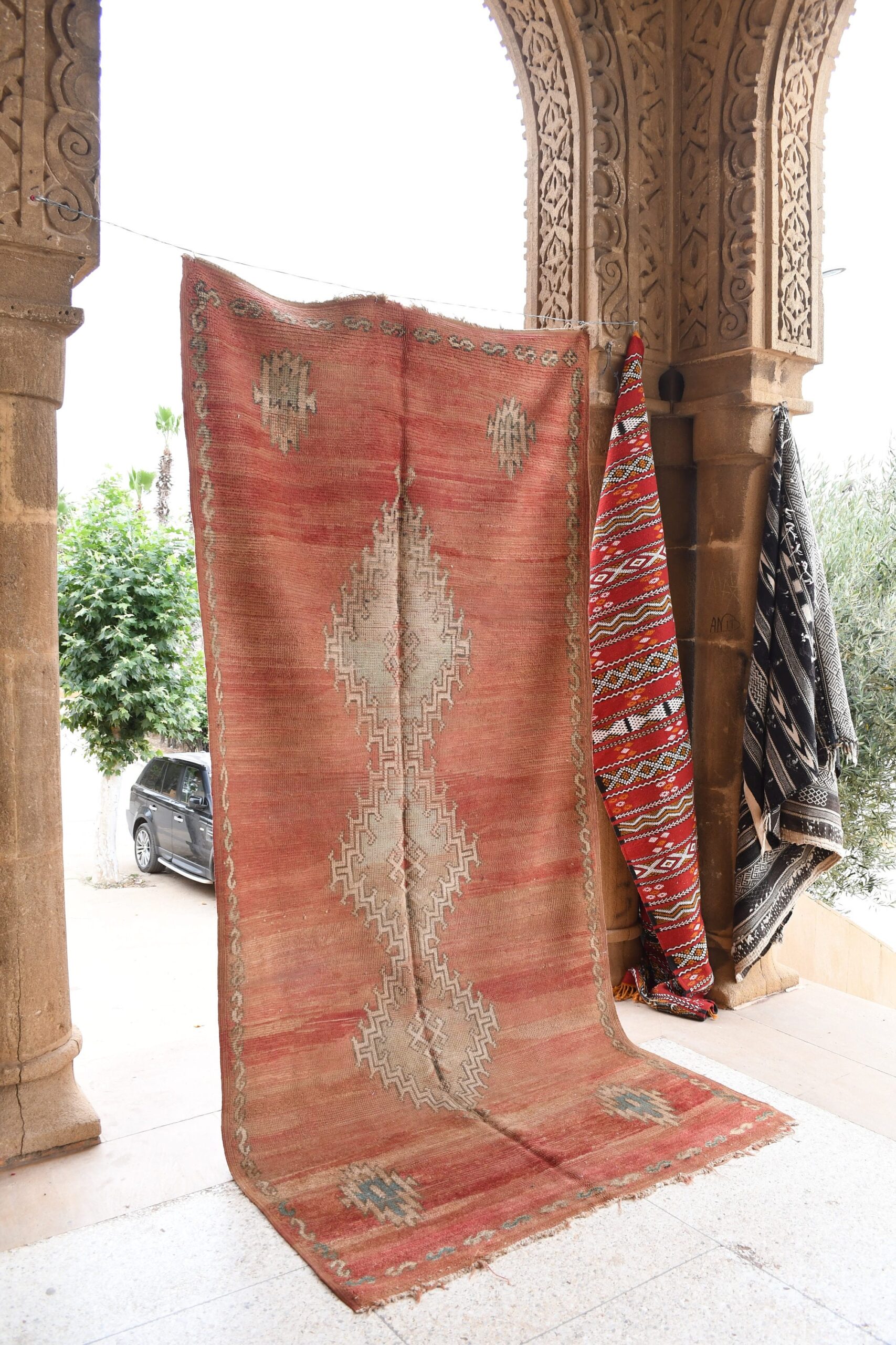 a red rug is hanging on a wall. il_fullxfull.6021352206_g6e2.jpg