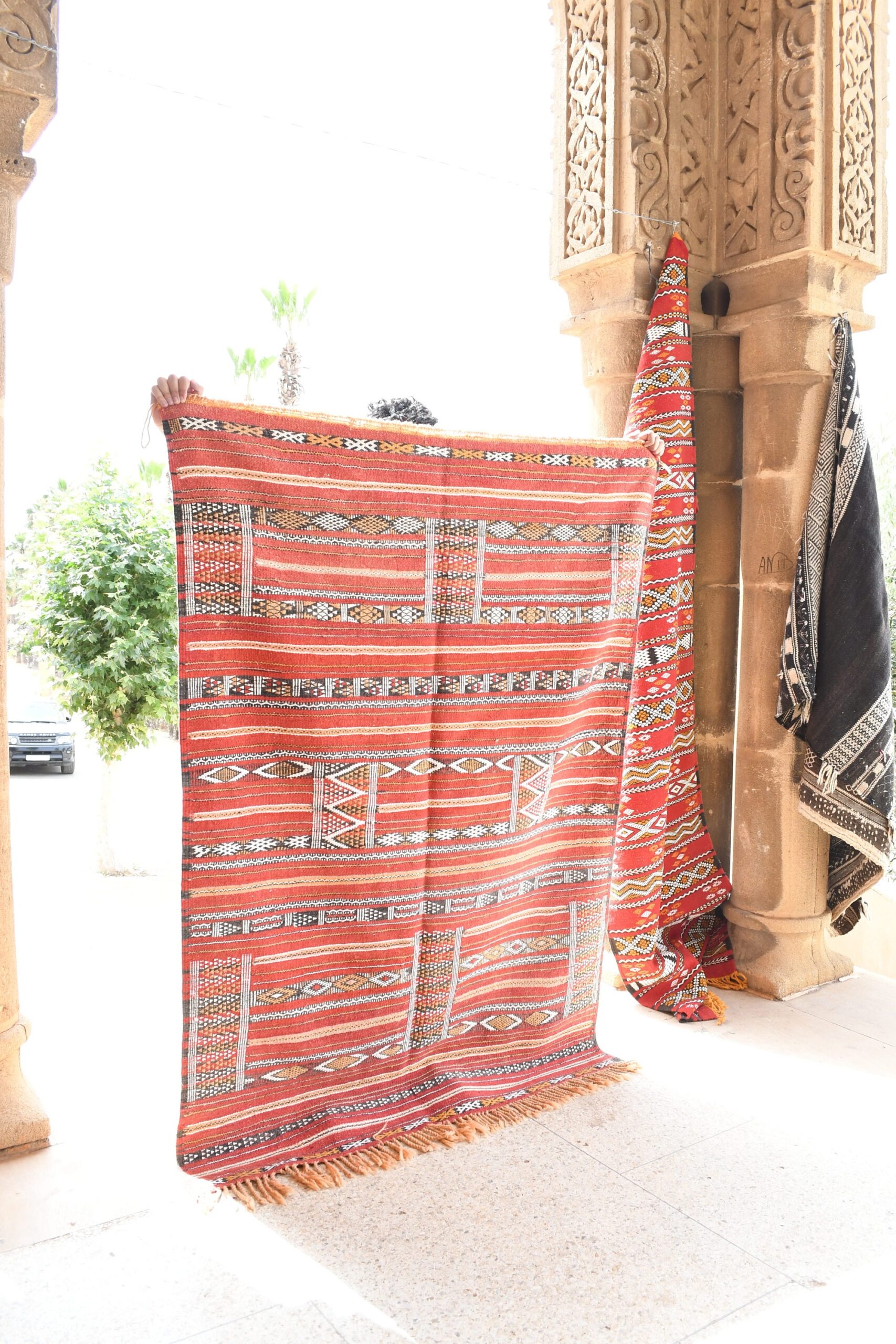a red and white moroccan rug hanging on a wall. il_fullxfull.6025853374_mjjc.jpg
