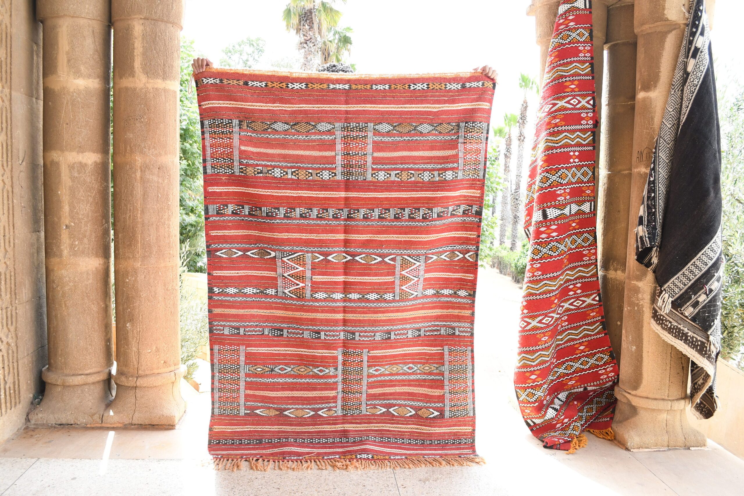 a red and white moroccan rug hanging on a wall. il_fullxfull.6025853490_hmfj.jpg