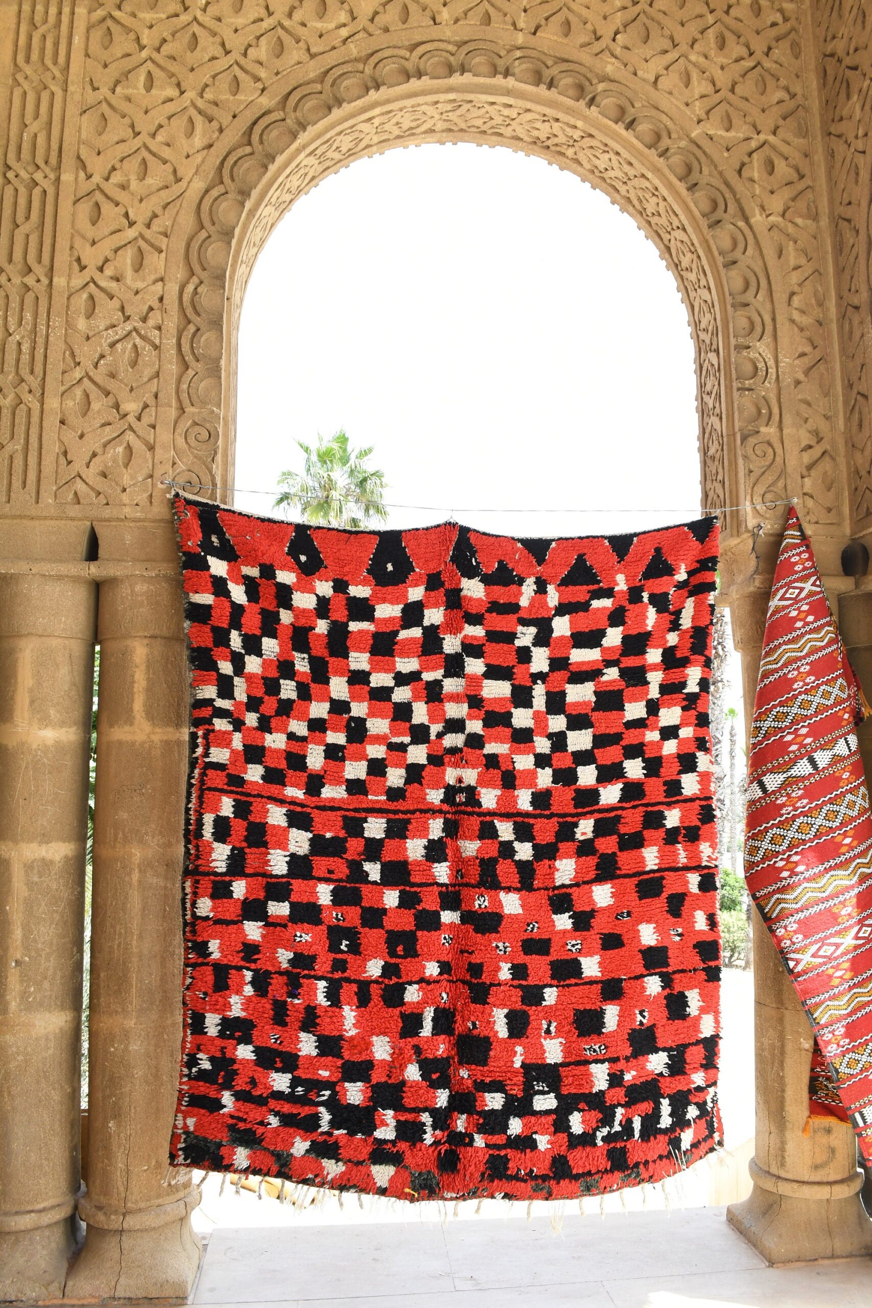 a red and black moroccan rug hanging on a wall. il_fullxfull.6025907082_8pej.jpg