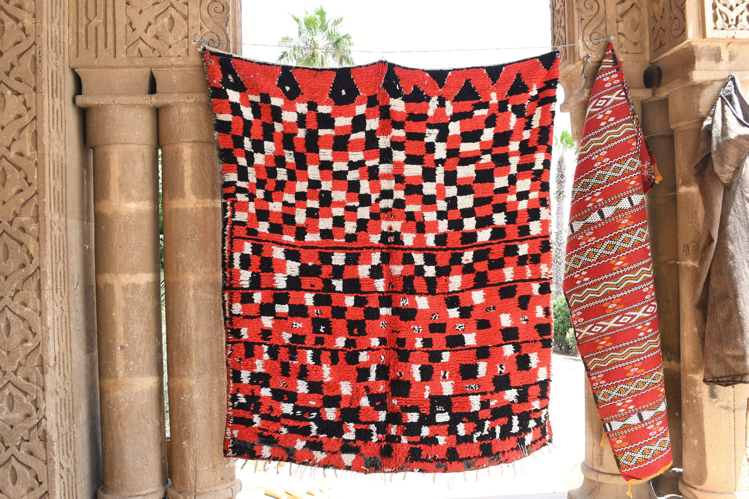 a red and black moroccan rug hanging on a wall. il_fullxfull.6025907592_6dmf.jpg