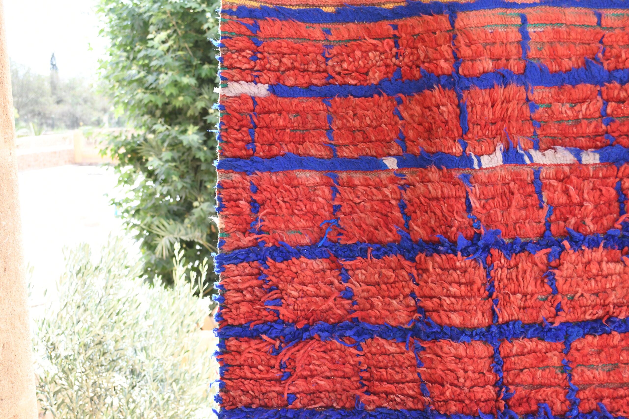 a red and blue rug hanging on a wall. il_fullxfull.6028110962_wguy.jpg