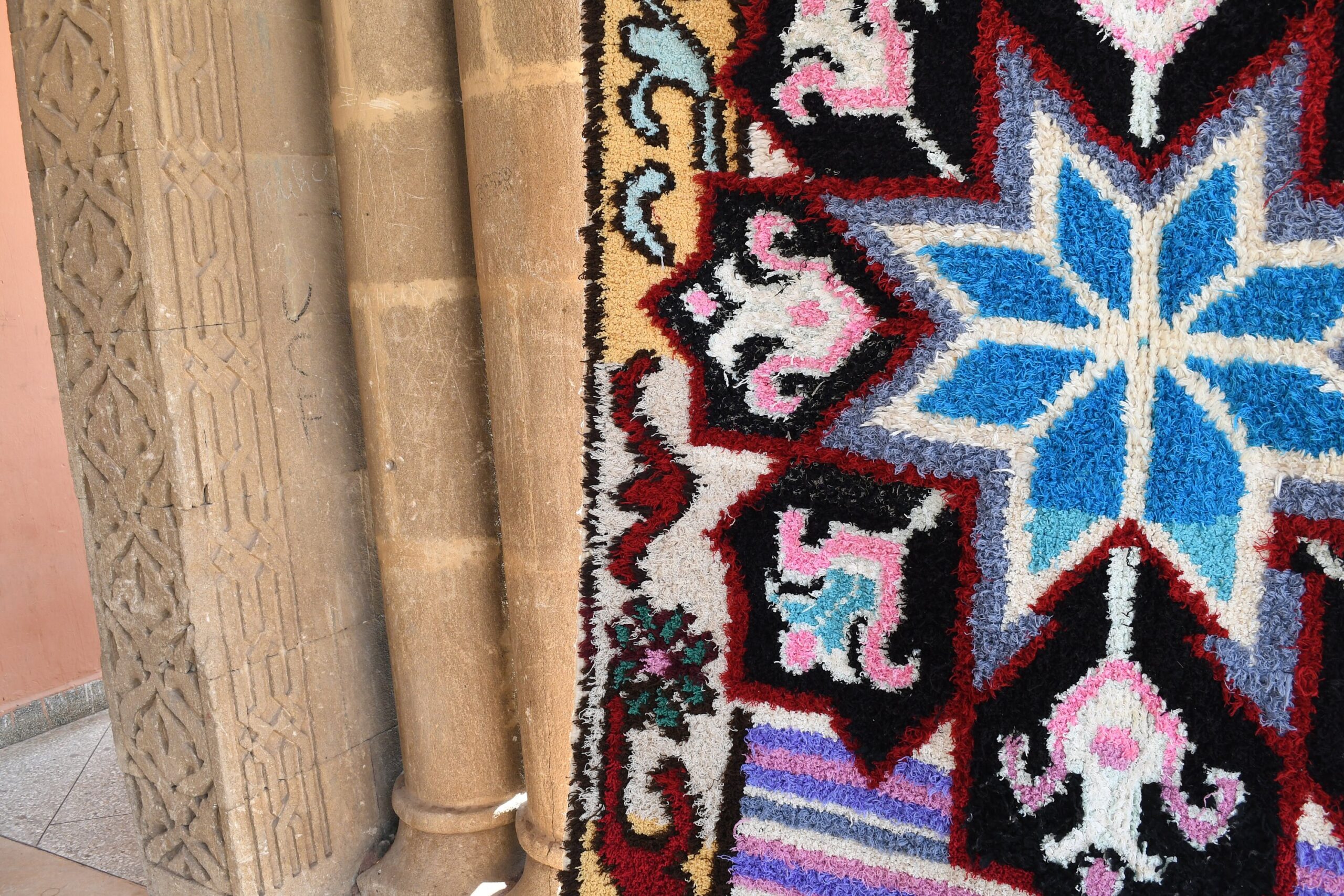 a colorful rug on a stone wall. il_fullxfull.6028205896_11ta.jpg