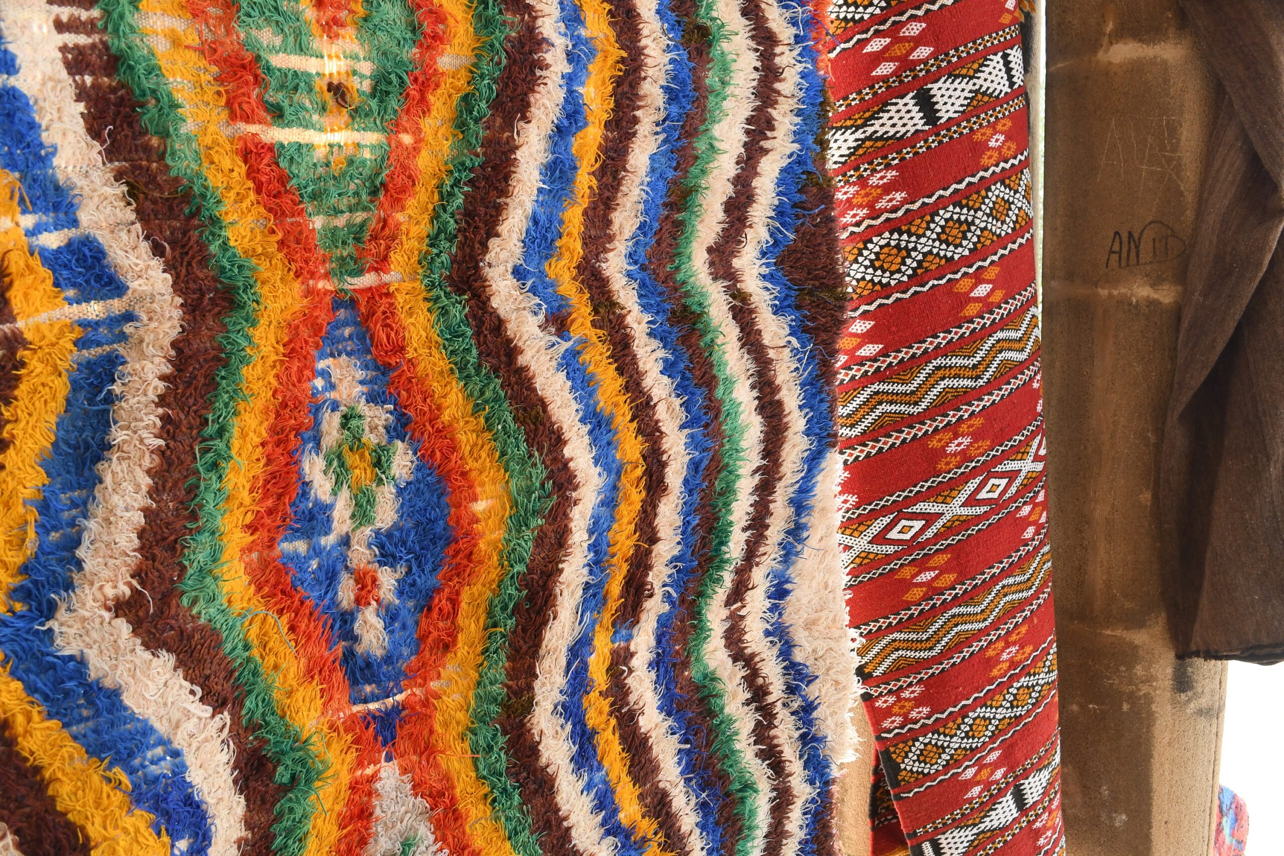 a colorfully colored moroccan rug hanging on a wooden pole. il_fullxfull.6028207412_mphz.jpg