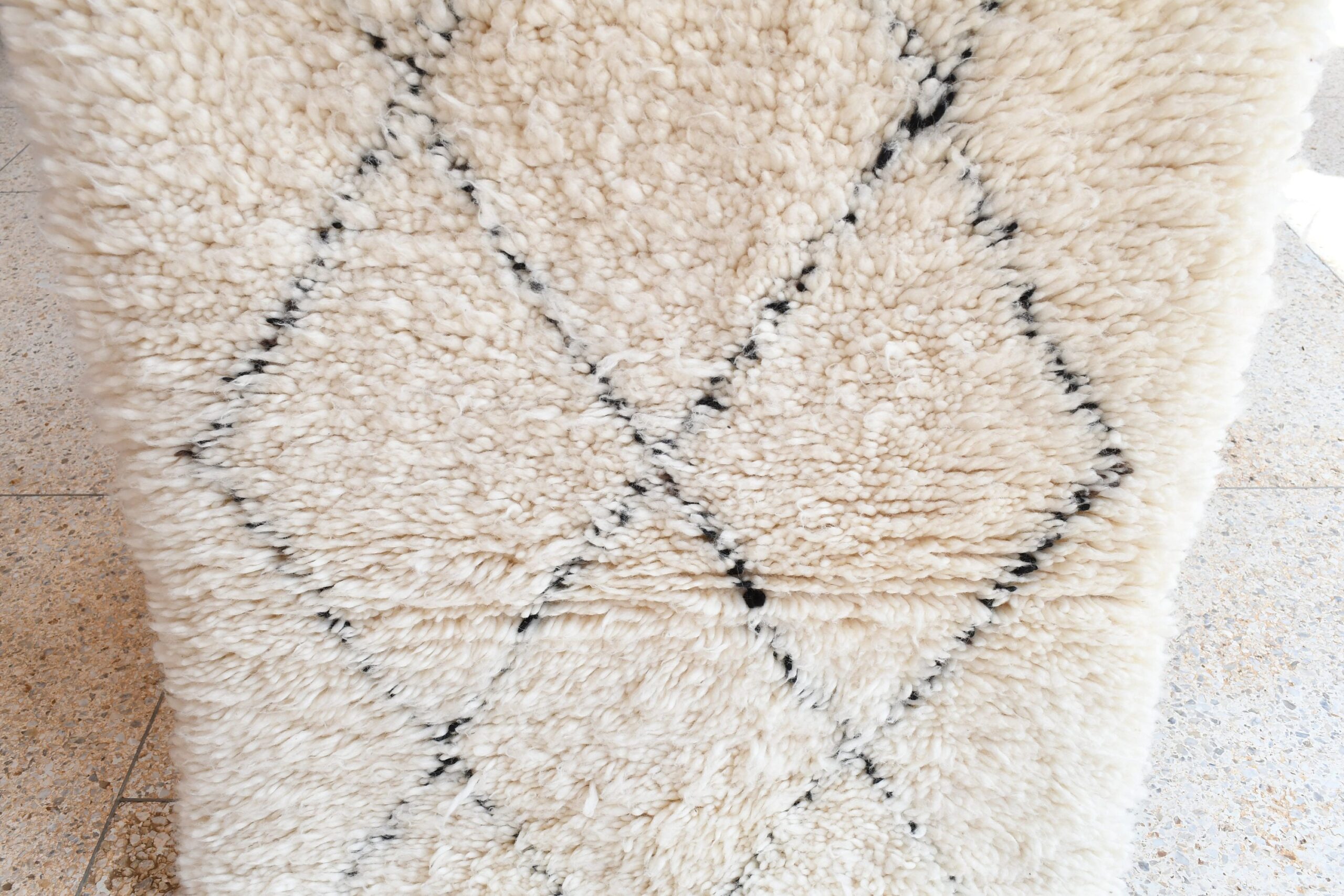 a white rug with black spots. il_fullxfull.6035090702_1yg6.jpg
