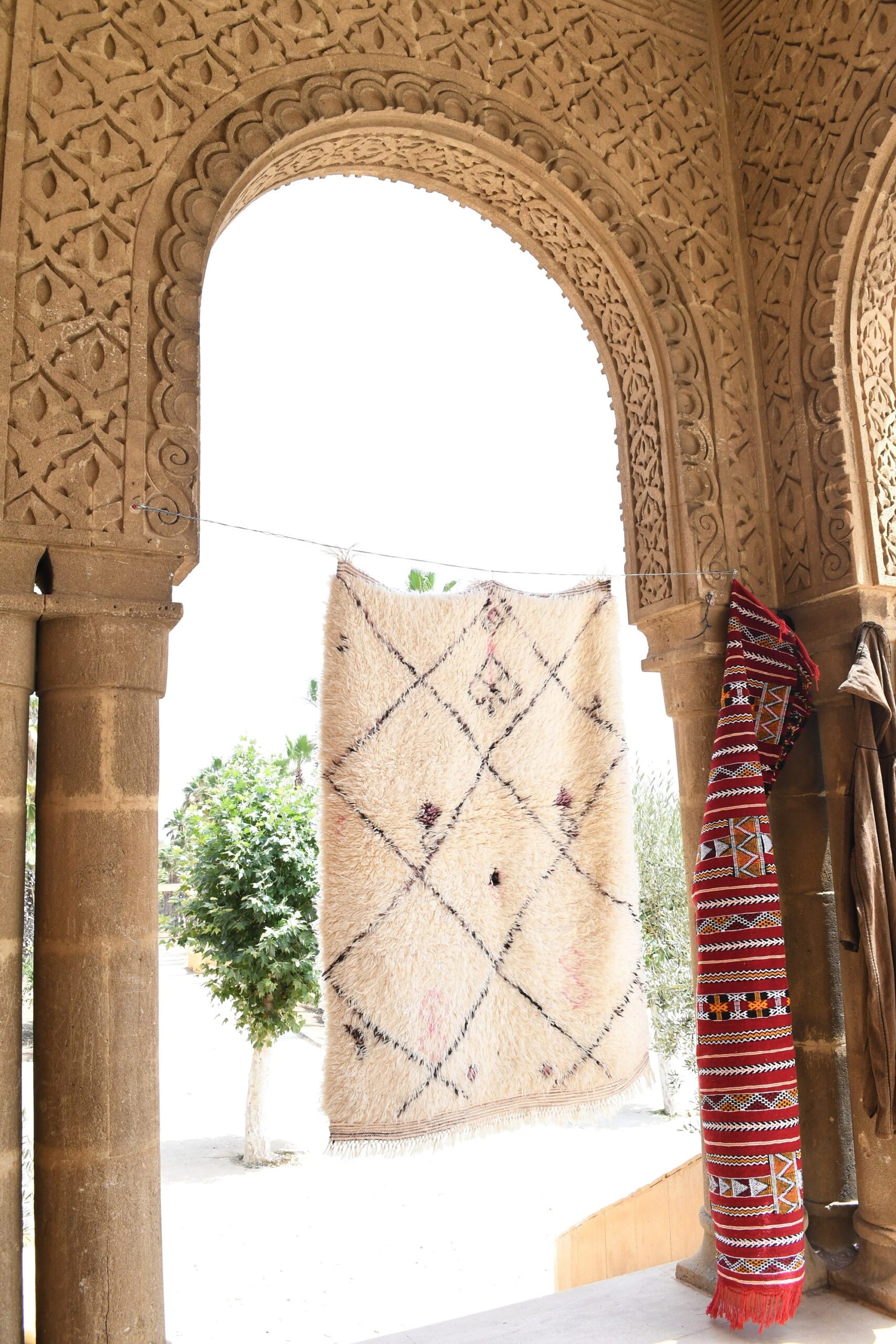 a woman standing in a doorway with a rug hanging from the ceiling. il_fullxfull.6036437622_5i35.jpg