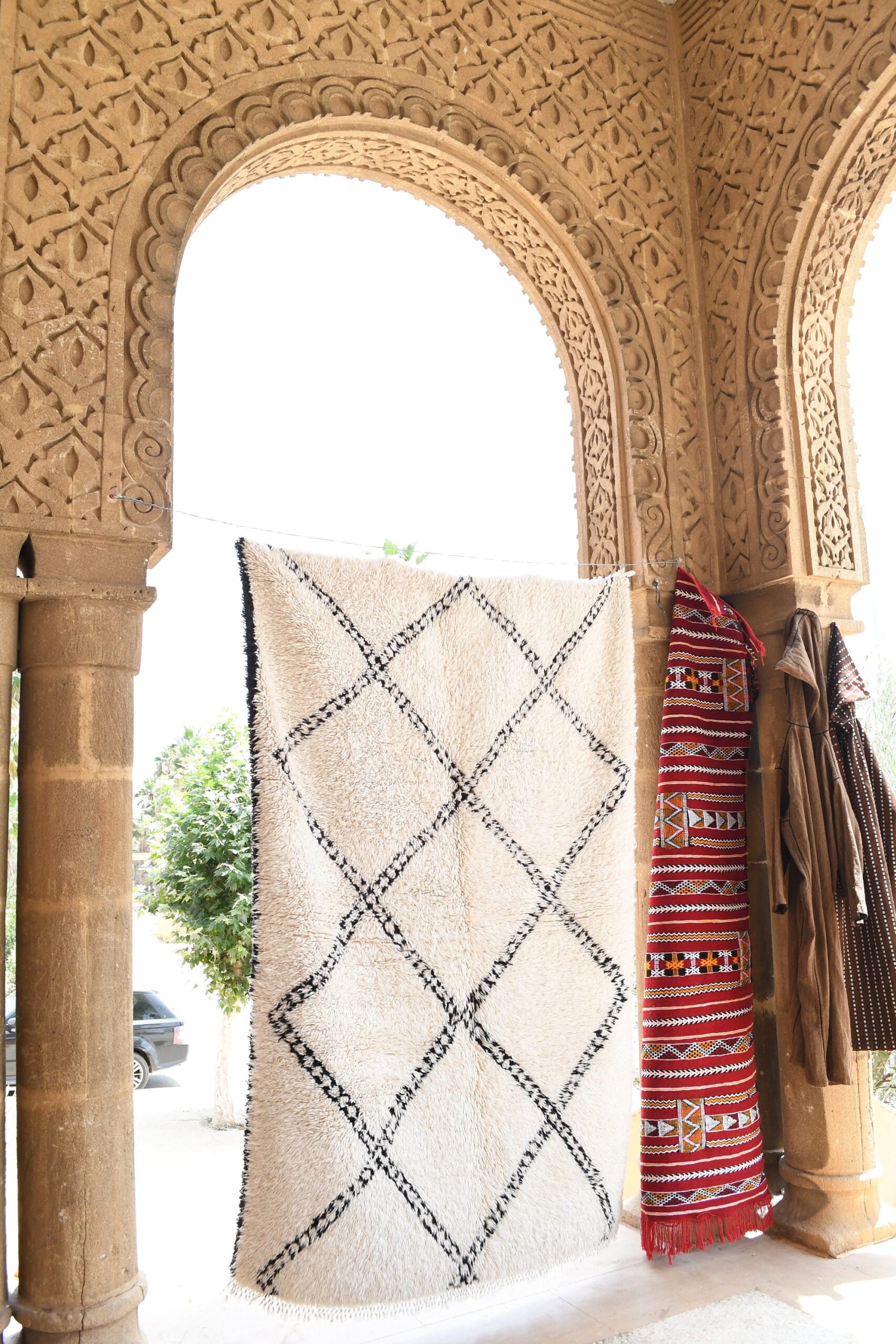 a white rug with a black and red design. il_fullxfull.6036460318_98sy.jpg