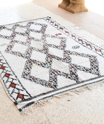 a white and black rug with a red and black design. il_fullxfull.6065262837_38pt.jpg