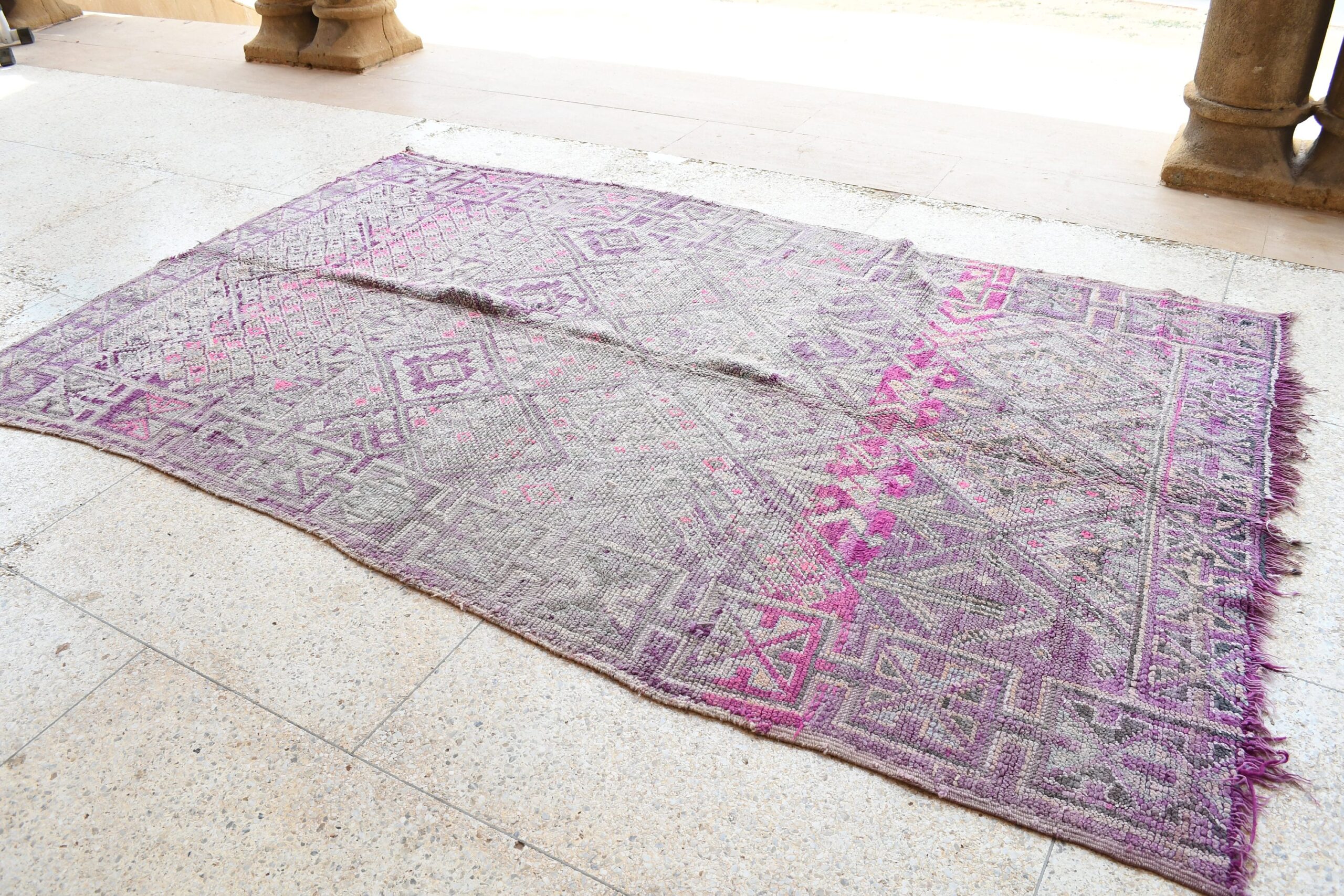 a purple and pink rug on a stone floor. il_fullxfull.6065528425_gcwj.jpg