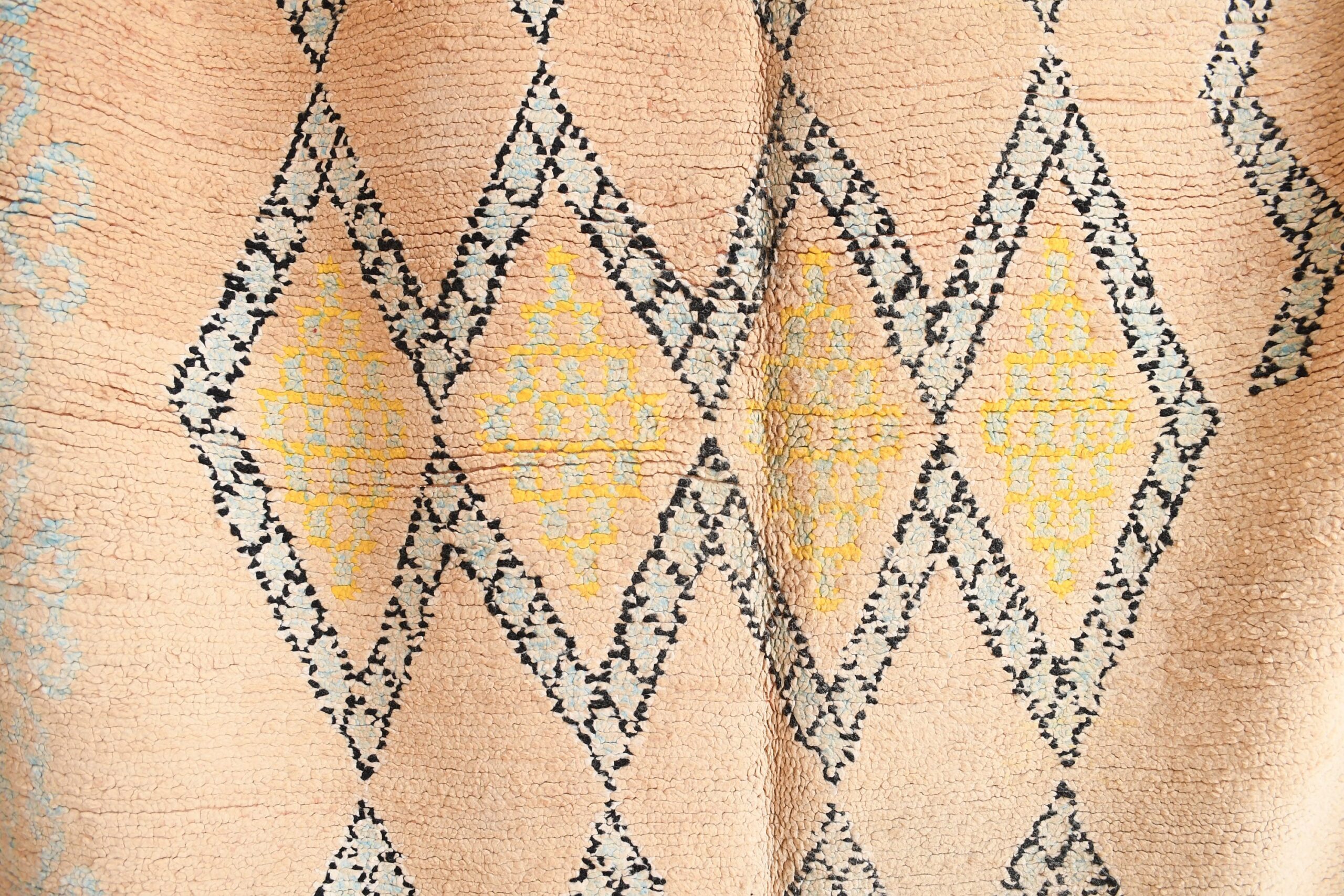 a close up of a beige and blue patterned moroccan rug. il_fullxfull.6065537671_c8nh.jpg