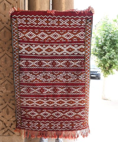 a red and white rug hanging on a pole. il_fullxfull.6065624775_rfch.jpg
