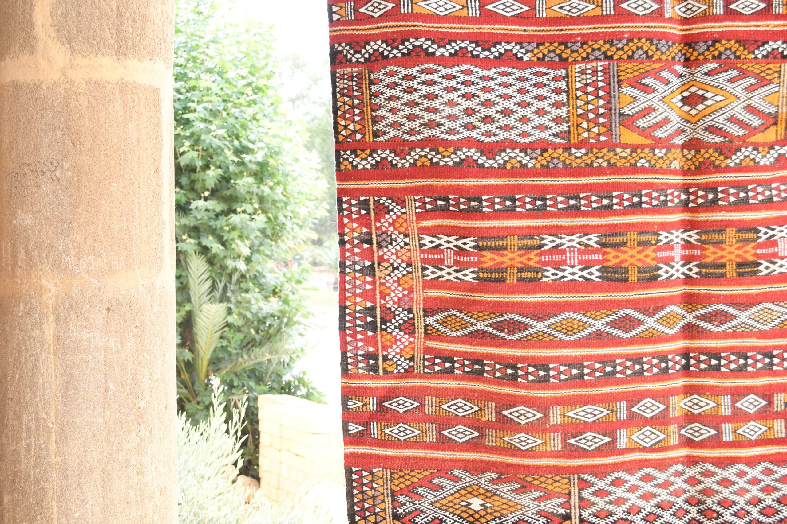 a red and white moroccan rug hanging on a wall. il_fullxfull.6065636747_5p2x.jpg
