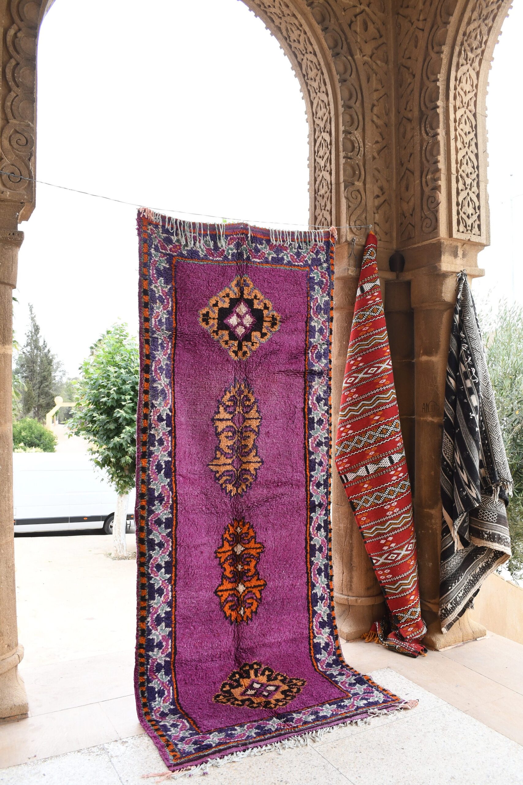 a purple and red rug hanging on a wall. il_fullxfull.6069418719_pvbz.jpg