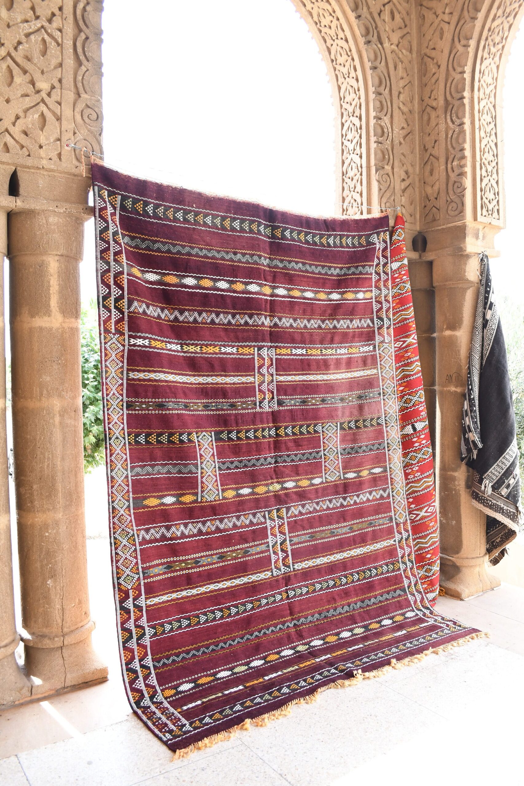 a large red and black rug on a stone floor. il_fullxfull.6073923033_1pd6.jpg