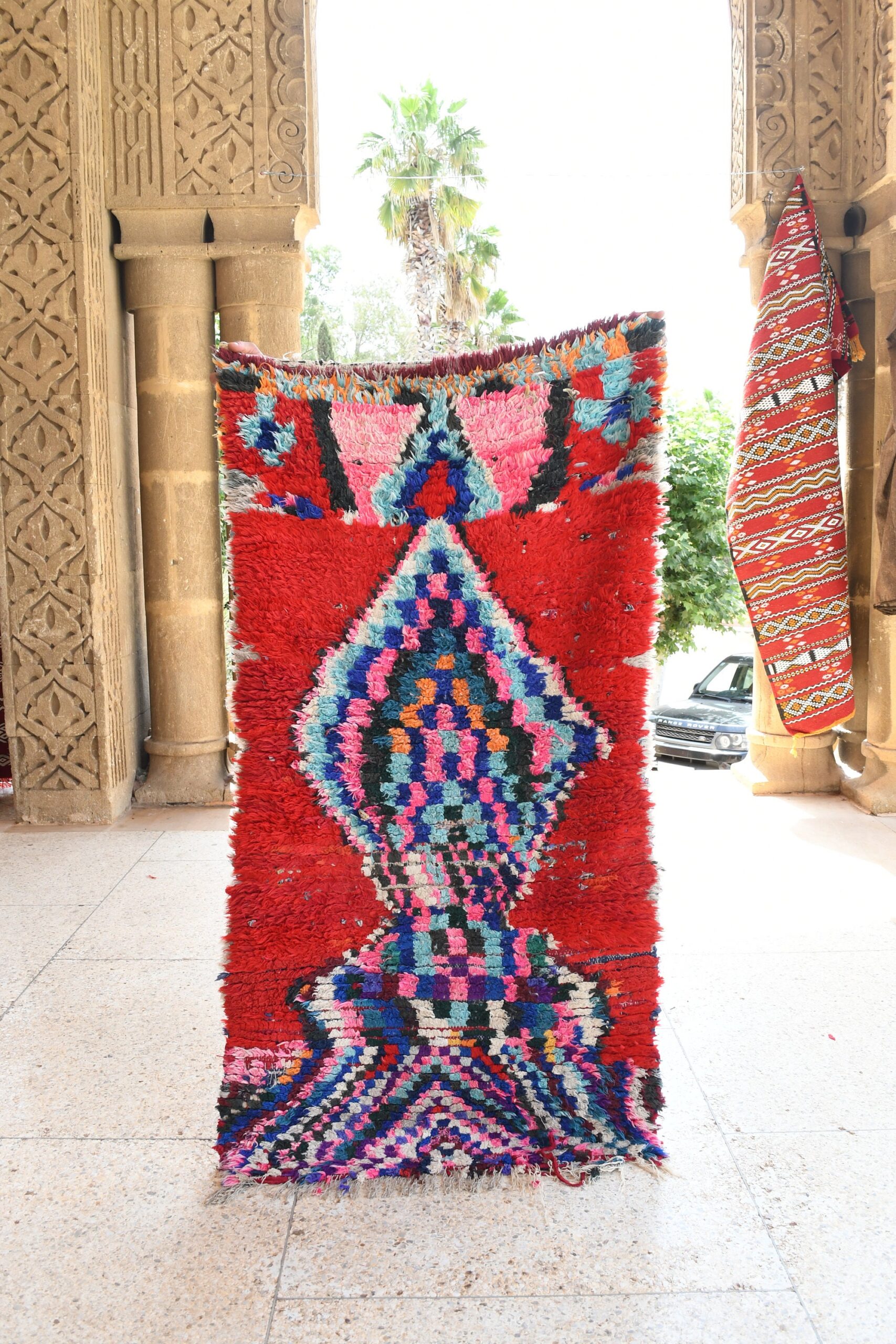 a red rug with a colorful pattern on it. il_fullxfull.6076170377_bws2.jpg