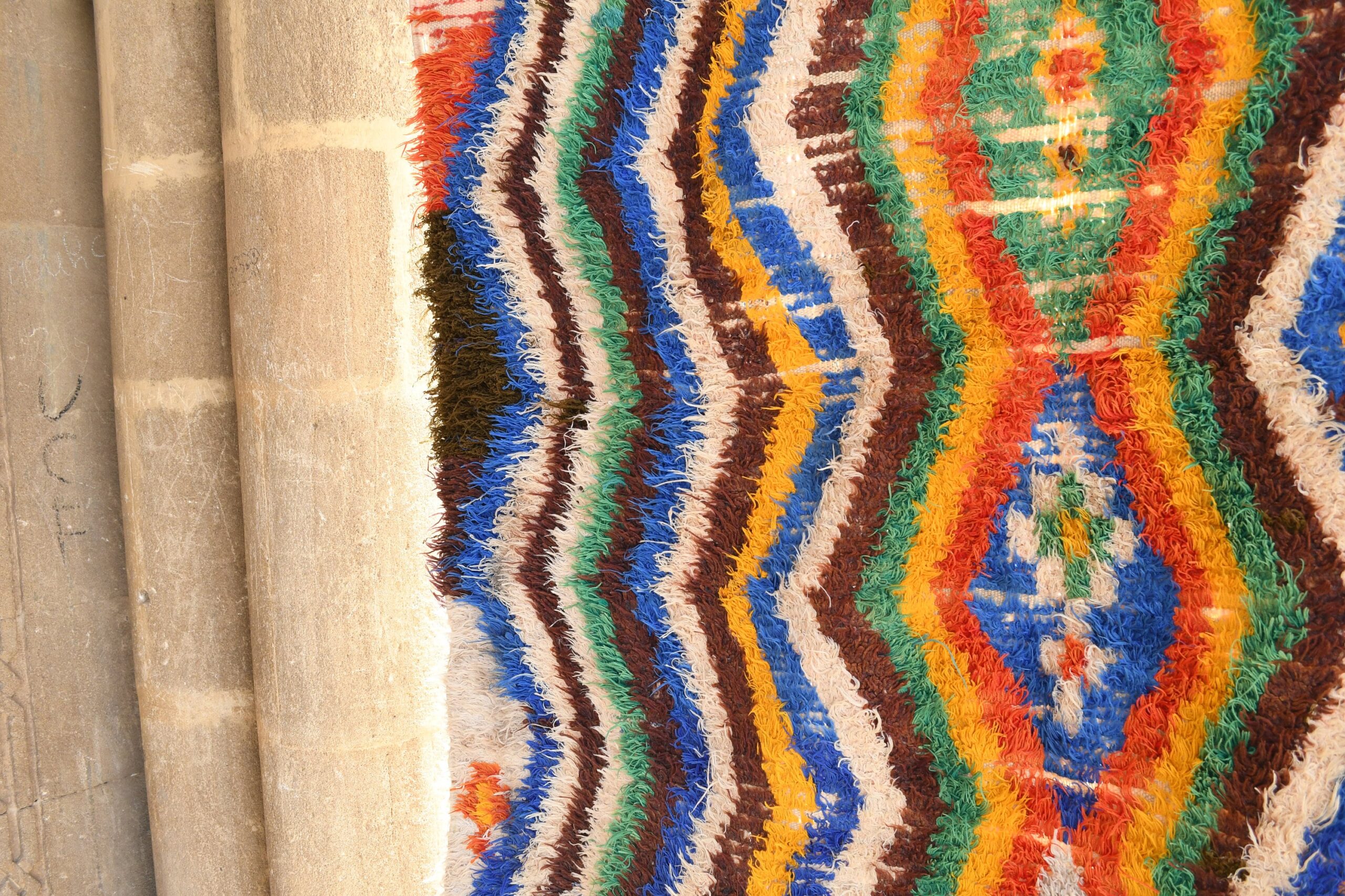 a colorful rug is hanging on a wall. il_fullxfull.6076273855_70wz.jpg