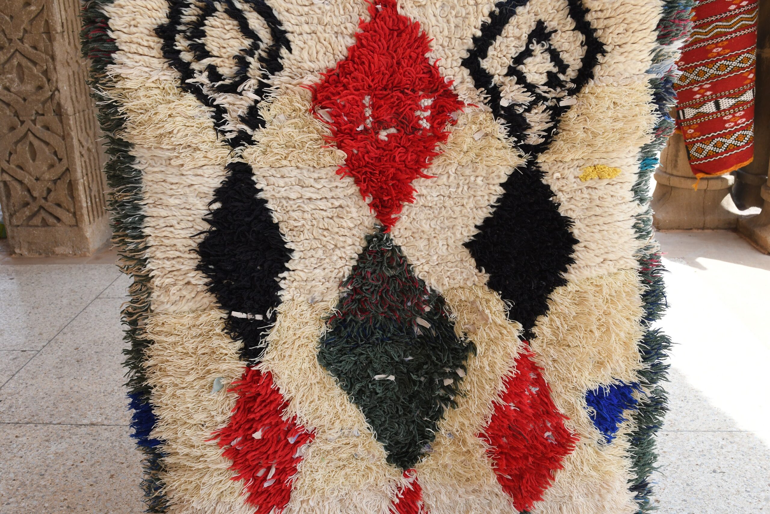 a large rug with a red and black design. il_fullxfull.6076305645_nile.jpg