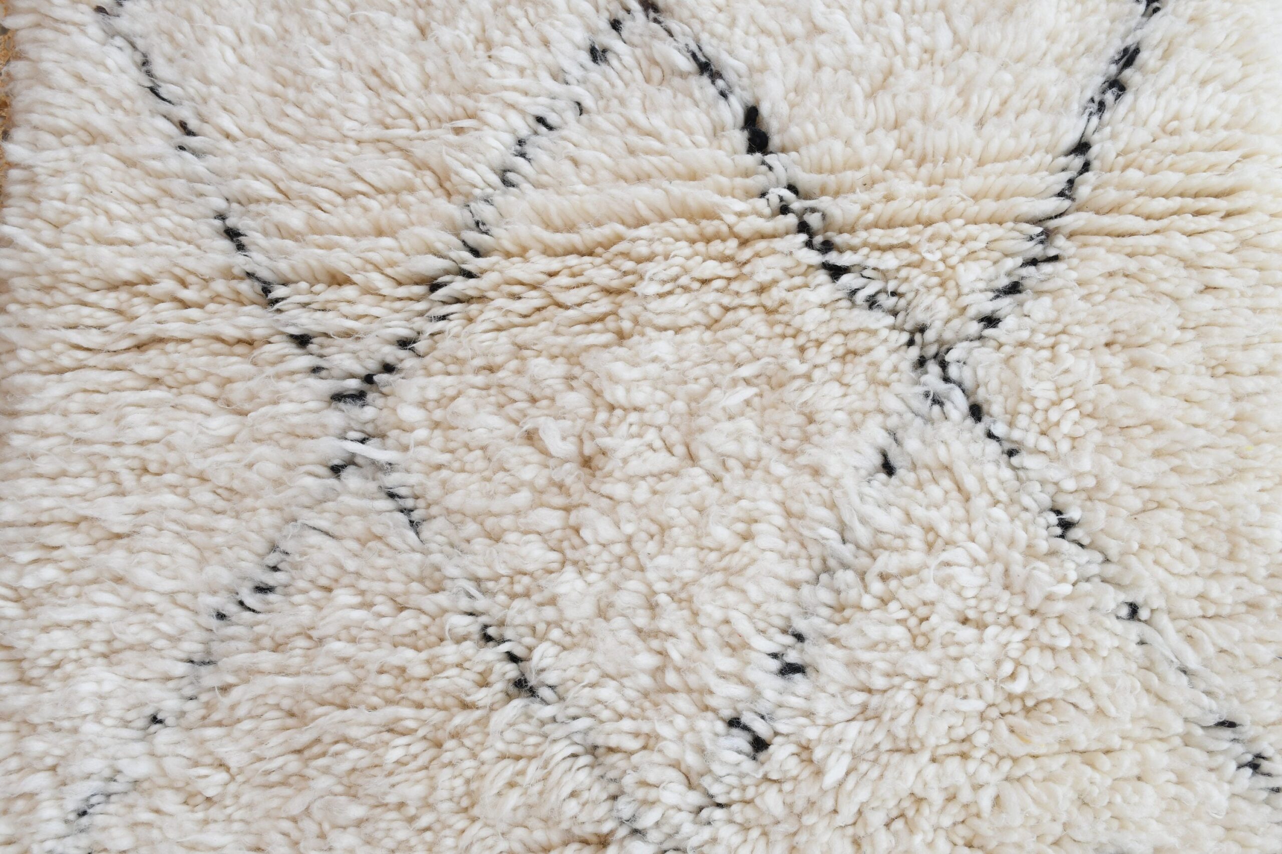 a white rug with black spots. il_fullxfull.6083151969_6qr0.jpg