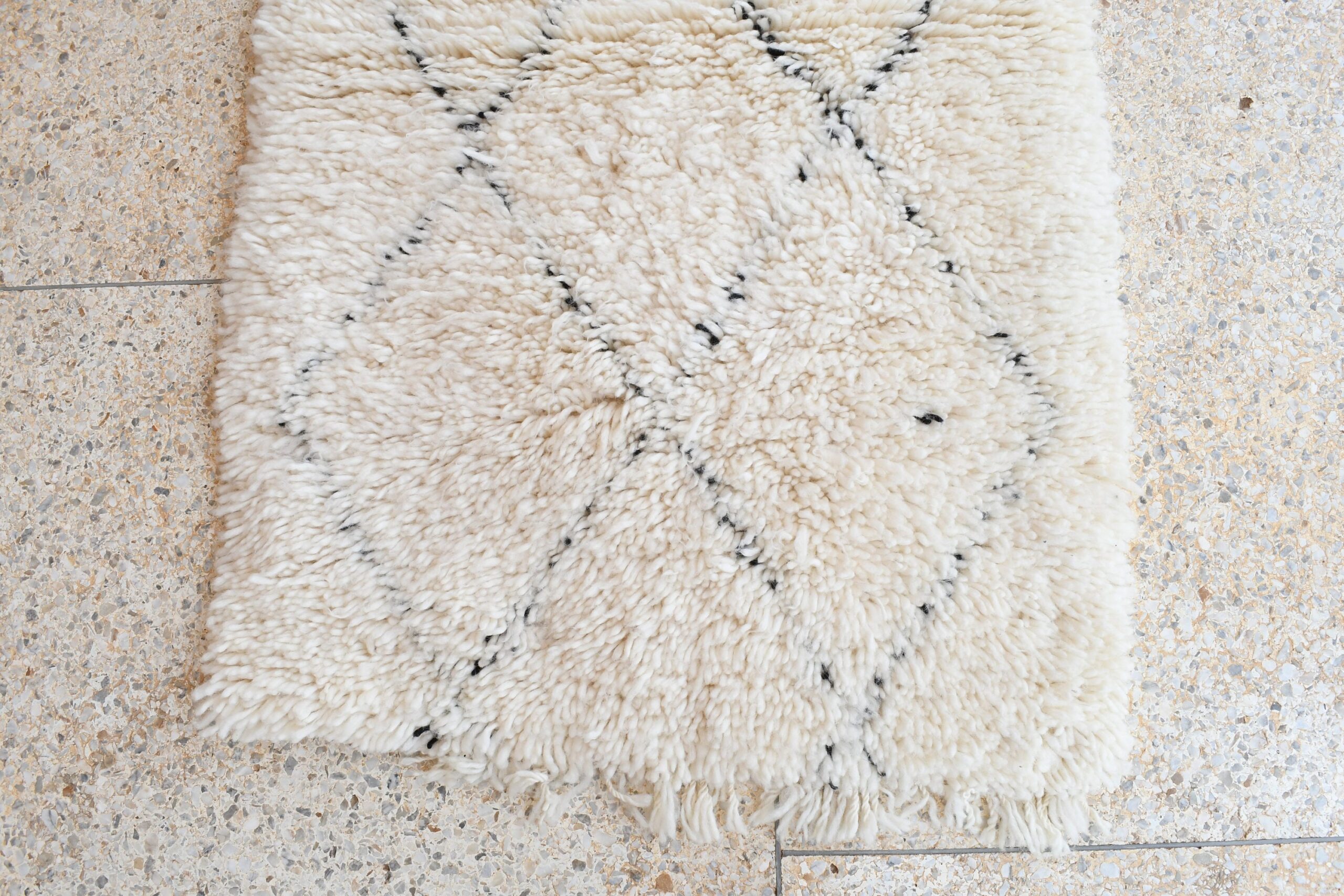 a white rug with black spots on it. il_fullxfull.6083152259_9n0n.jpg