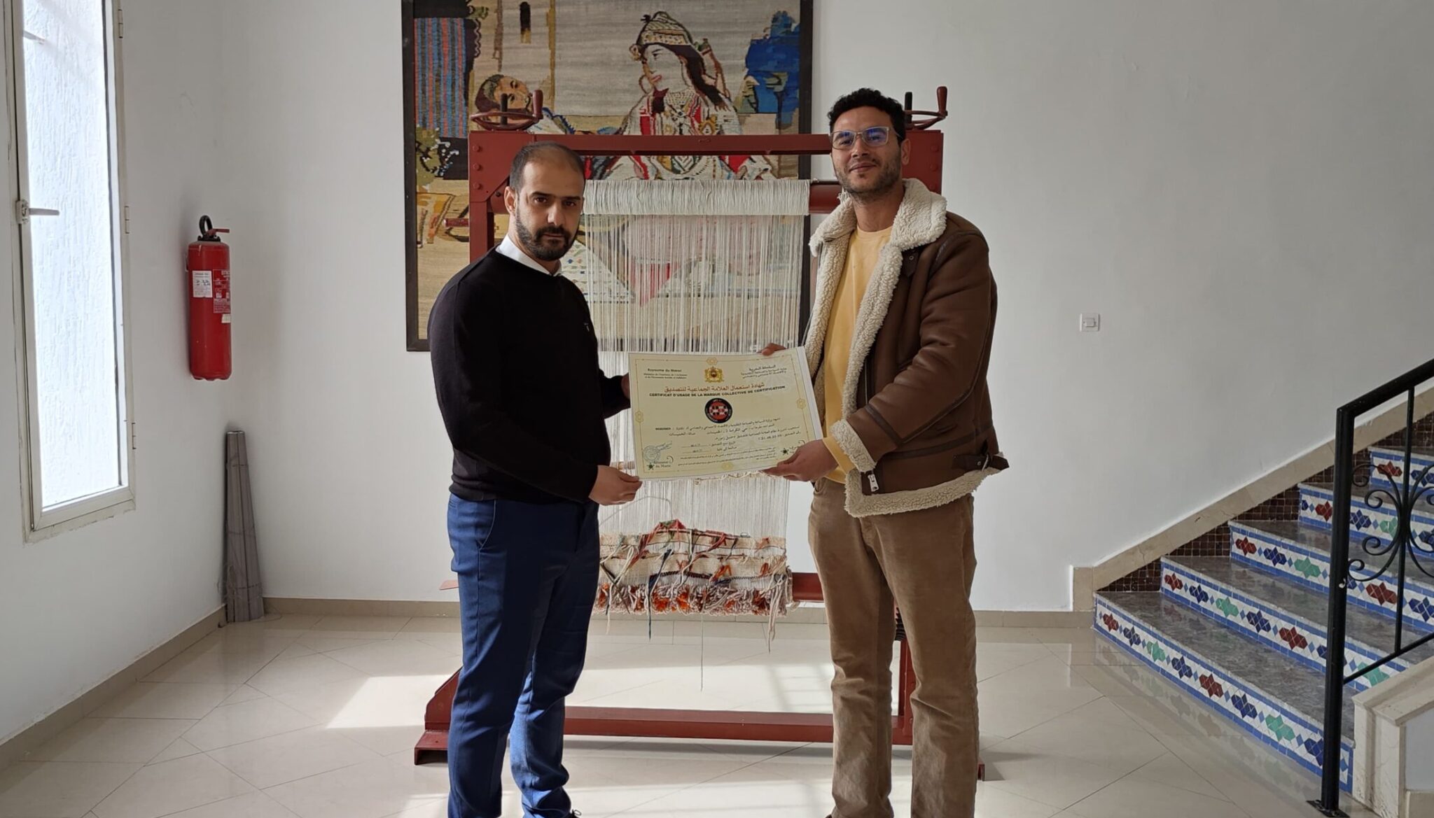 two men standing in front of a painting. Certification by the Moroccan Ministry of Tourism and Handicrafts